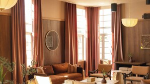 Un salón amplio con un sofá marrón, una mesa de centro redonda y sillas modernas.