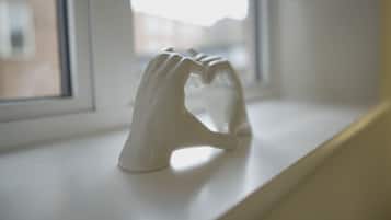 A white ceramic sculpture on a windowsill.