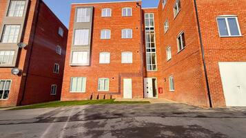 A multi-story brick building with a central entrance and multiple windows.