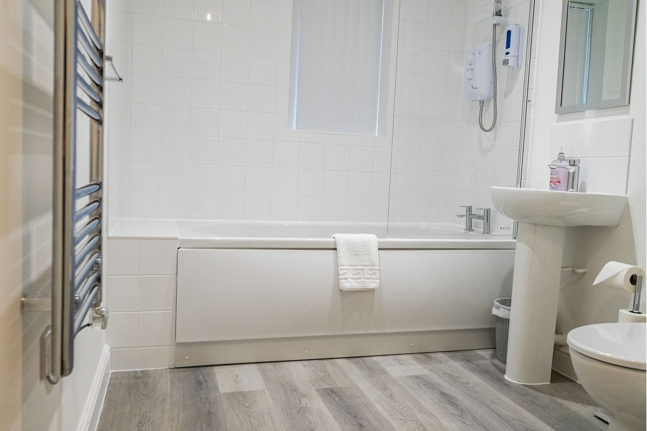 Ein modernes Badezimmer mit Badewanne, Waschbecken und Toilette.