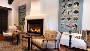A cozy living room with a fireplace, patterned wall art, and comfortable seating.