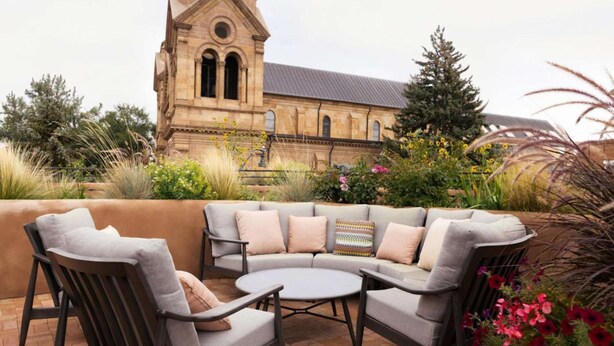 An outdoor seating area with a stone building in the background.
