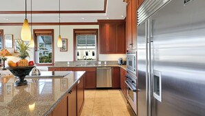 Une cuisine moderne dotée d’appareils électroménagers en acier inoxydable, d’armoires en bois et d’un plan de travail en granit.