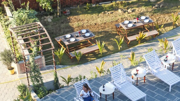 A rooftop pool area with lounge chairs, a hot tub, and a dining setup. - Hotel Yatra Sauraha (Sauraha)