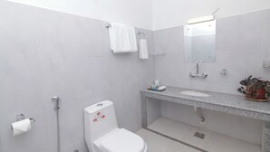 A modern bathroom with a toilet, sink, and shower. - Hotel Yatra Sauraha (Sauraha)