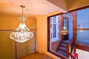 A grand staircase with a wooden handrail and a glass door leading to a brick exterior. - The Godalming Hotel (Godalming)
