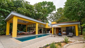 A modern house with a swimming pool, yellow exterior, and a covered patio area. - Charming 3-bedroom villa in fabulous Puerto Carrillo with WiFi, AC (Puerto Carrillo)