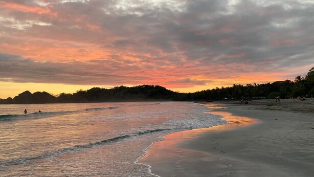 A beach with waves, a sunset, and a forest in the background. - Charming 3-bedroom villa in fabulous Puerto Carrillo with WiFi, AC (Puerto Carrillo)
