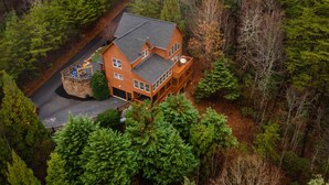 A large, two-story house surrounded by dense forest. - Comfort and Luxury at its best, Hot Tub 1 Dog. New Property (Blairsville)