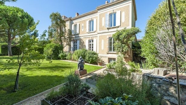 A two-story building with a garden in front.