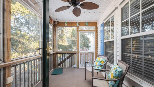 A covered porch with a ceiling fan, wooden railings, and a view of trees. - 5 Min Walk to Nags Head Beach, Centrally Located! (Nags Head)