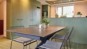 A modern kitchen with a large dining table, chairs, and potted plants. - Luxurious townhouse in AAA location with nearby parking. (Brugge)
