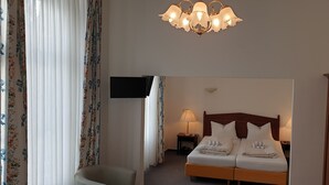 A hotel room with a bed, bedside lamps, a TV, and a wooden wardrobe. - Hotel Eifeler Hof Kyllburg (Kyllburg)