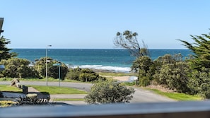 Enjoy a scenic drive along the coast with ocean views and a tranquil beach in the distance.