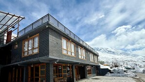 A two-story building with a balcony and large windows. - The Bulevar-Kunsil (Lahul)