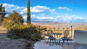 Une terrasse avec une table et des chaises donnant sur un paysage pittoresque.