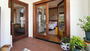 Une pièce avec un lit, une fenêtre et une porte donnant sur une autre pièce.