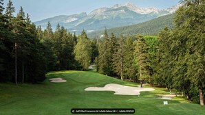 Un campo de golf con vistas despejadas a montañas al fondo.
