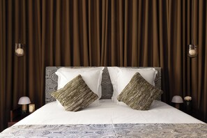 A neatly made bed with patterned bedding, two decorative pillows, and a headboard with a paisley design. - Palais Bourbon Hotel - Room 42 - 2P - Invalides (Paris)