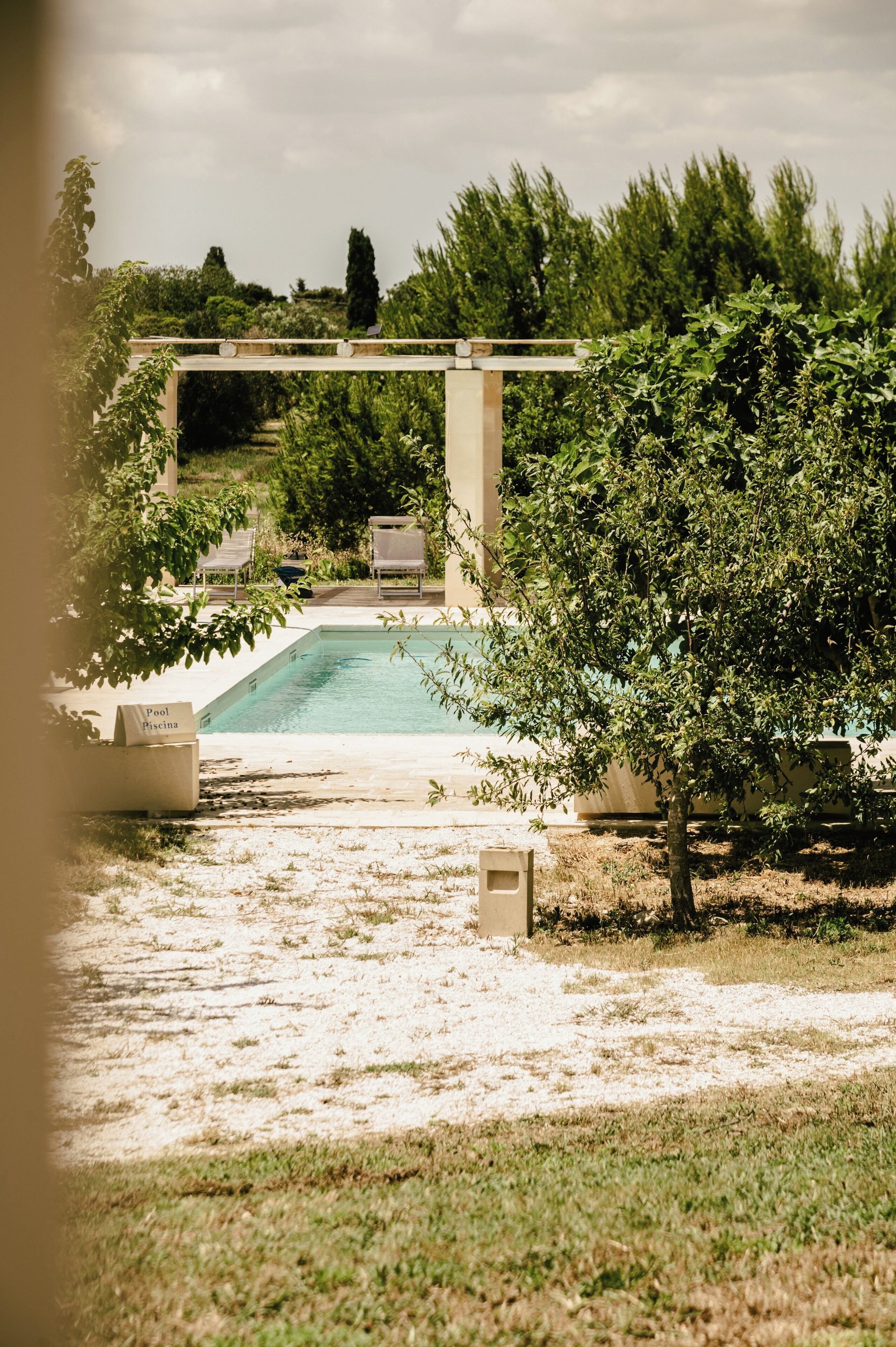 Un espace piscine agrémenté d’une pergola, de chaises longues et d’un panneau indiquant la présence d’une piscine.