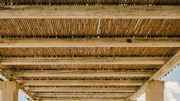 An outdoor pavilion with a bamboo roof, concrete pillars, and sun loungers. - Villa Del Ponente Otranto (Otranto)