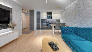 A modern living room with a sofa, coffee table, and TV. - Seaside Przystań Letnica by Downtown Apartments (Gdansk)