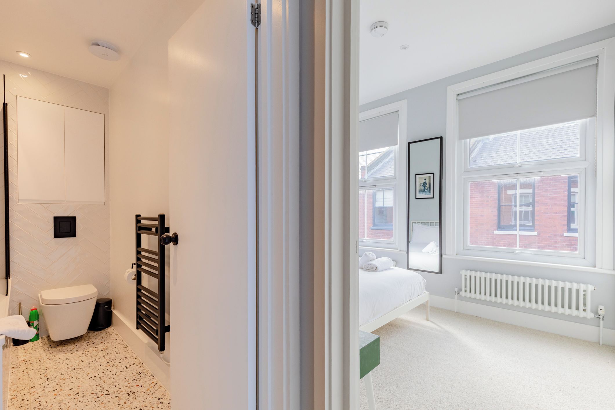 A modern bathroom with a toilet, sink, and towel rack.