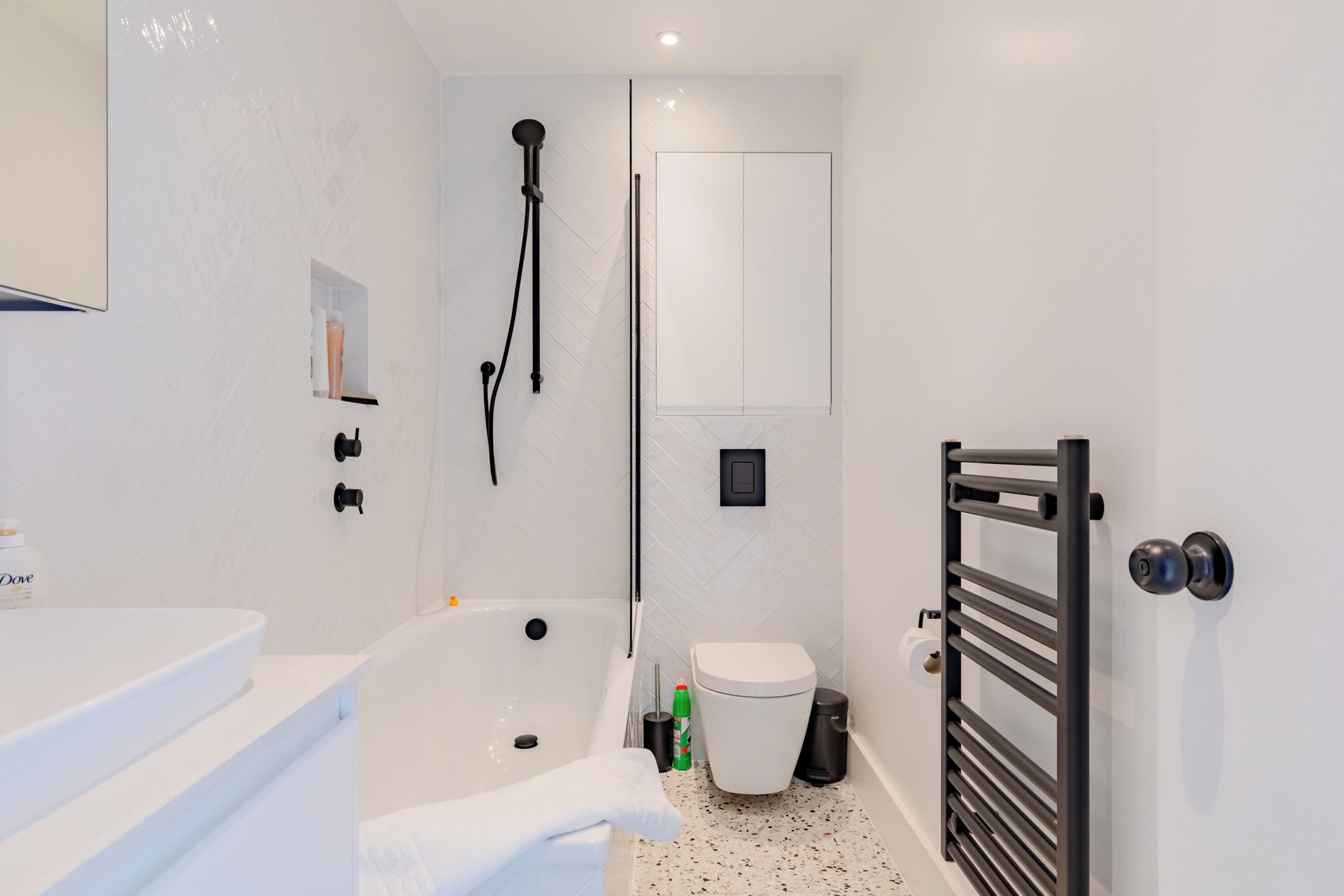 Ein modernes Badezimmer mit einem weißen Waschbecken, einer Badewanne und einer Toilette.