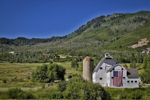 A rural landscape with a barn and silo, surrounded by green fields and hills. - Moose Mgmt at Retreat 13548: Hot Tub, King Bed, 10min to Town and Ski Resorts (Park City)