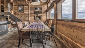 A wooden interior with a dining table, chairs, and a staircase. - Ski-in-ski-out 4/5-bedroom chalet loft with jacuzzi in Les Houches, Chamonix (Les Houches)