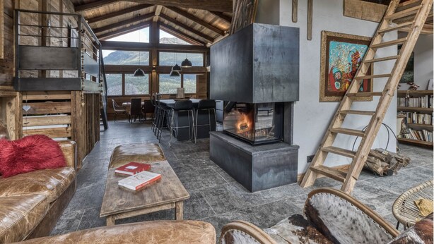 A rustic interior with a fireplace, wooden furniture, and a view of the mountains. - Ski-in-ski-out 4/5-bedroom chalet loft with jacuzzi in Les Houches, Chamonix (Les Houches)