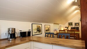 A kitchen with a wooden countertop, a coffee maker, and framed artwork on the wall. - Ferienwohnung im Reetdachhaus, Burhave (Butjadingen)