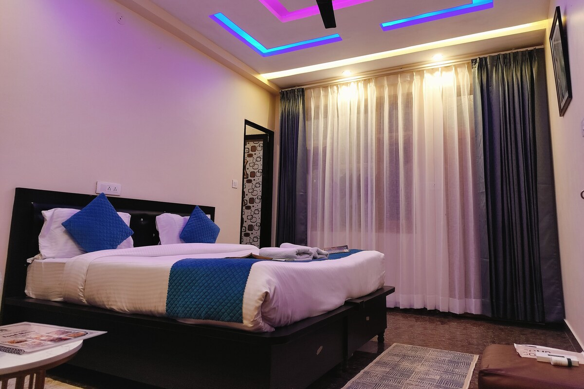 Un dormitorio moderno con cama, mesitas de noche, ventilador de techo y ventana con cortinas.