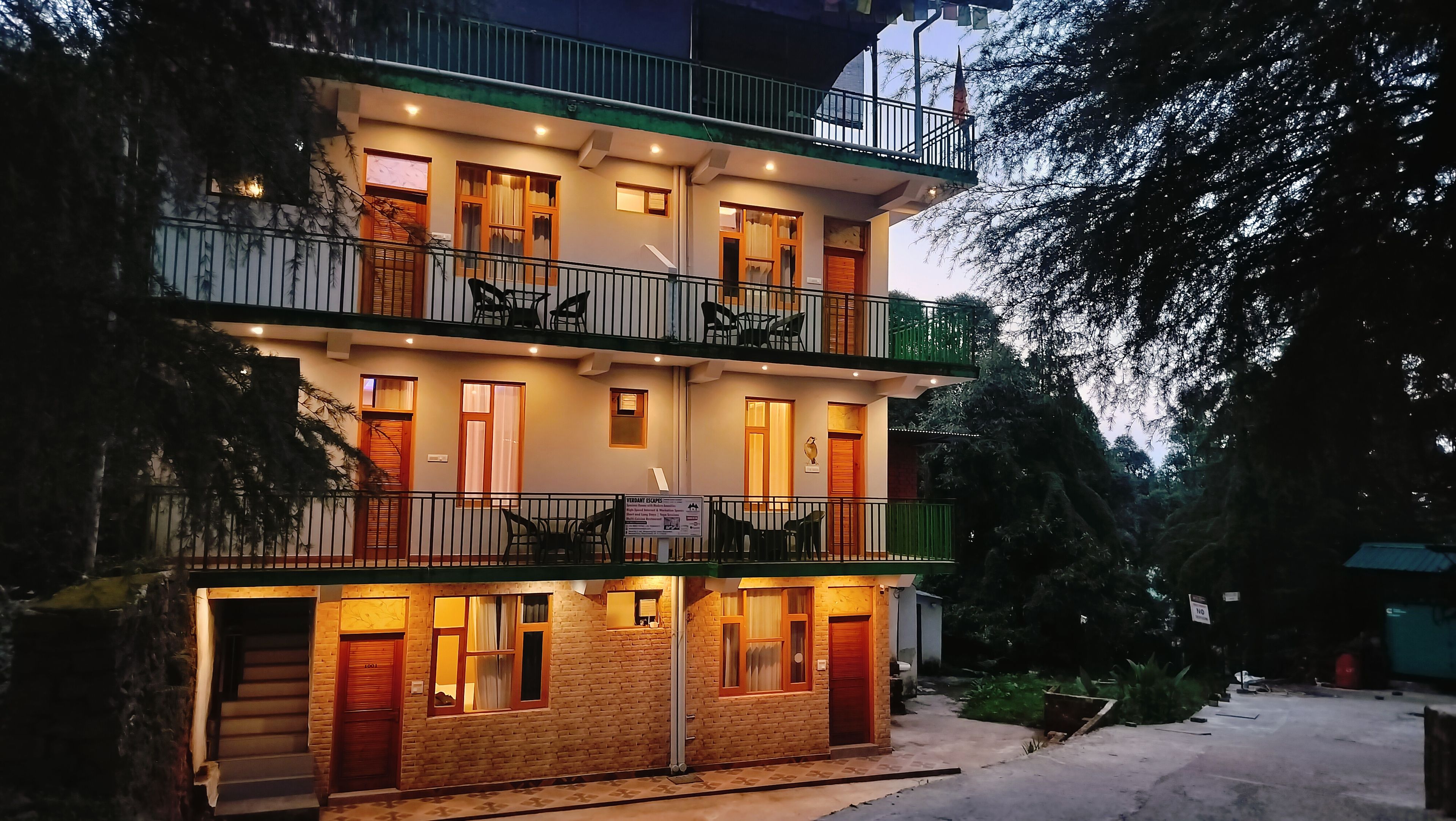 A multi-story building with balconies, windows, and a signboard.