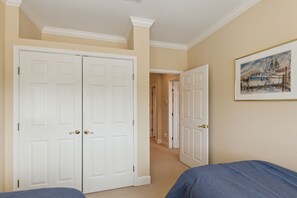 Un dormitorio con dos camas, un pasillo y una puerta que da a otra habitación.