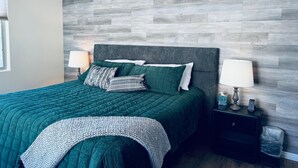 Ein Schlafzimmer mit einem Bett, zwei Nachttischlampen, einem Nachttisch und einem Deckenventilator.