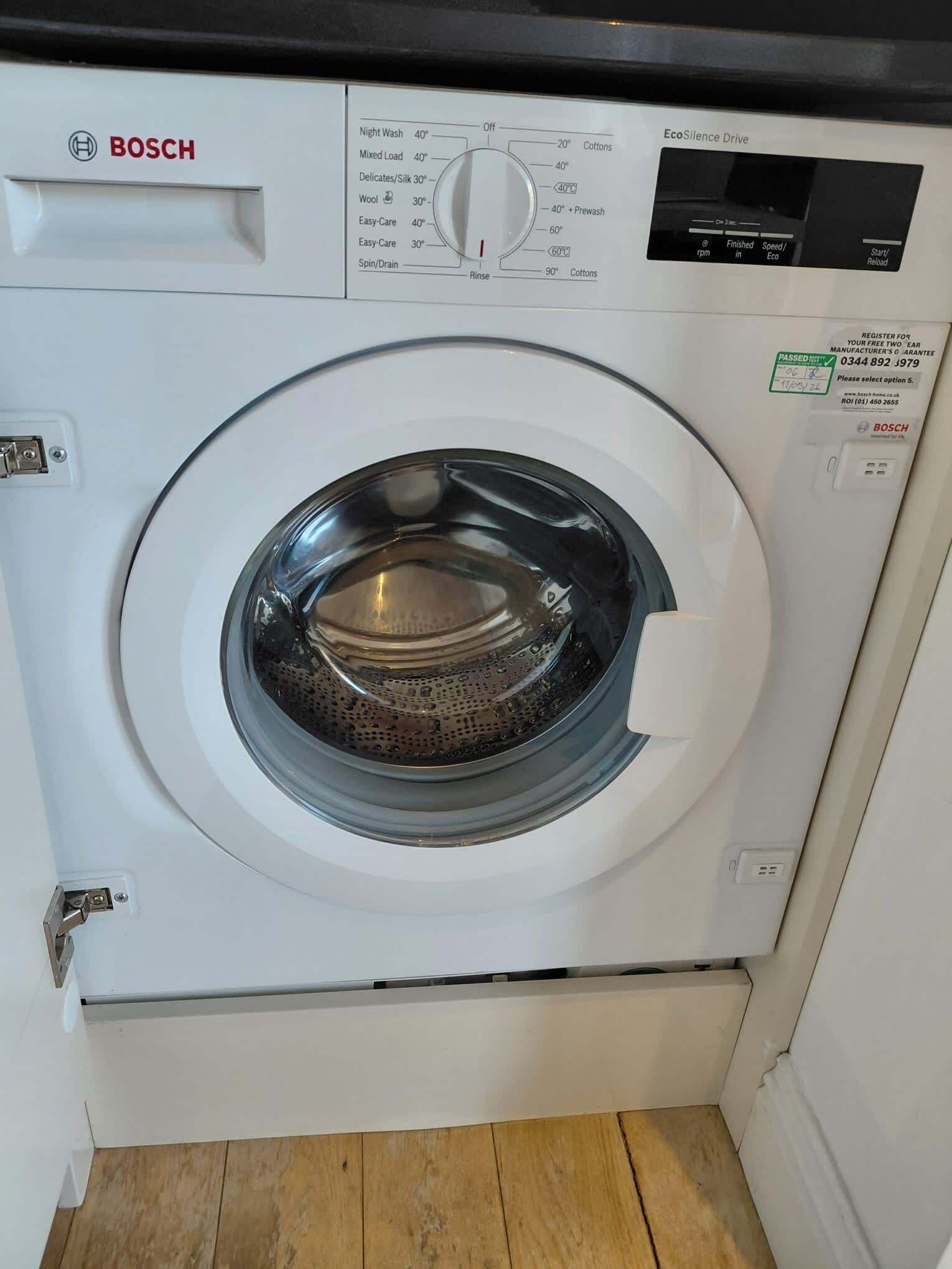 Una lavadora Bosch con panel de control, pantalla digital y una pegatina de aprobación.