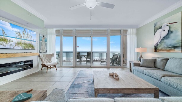 A spacious living room with a large sliding glass door leading to a balcony with ocean views.