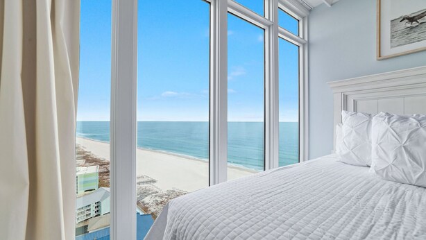 A bedroom with a large window overlooking a beach. - Newest Beachfront Complex!!  Professionally Decorated 4BR!!  Lazy River!! (Orange Beach)