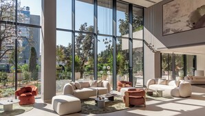 A spacious living area with large windows, modern furniture, and a view of the outdoors. - Hotel Sumratin (Dubrovnik)