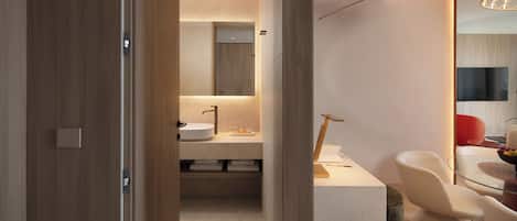 A modern bathroom with a wooden door, a sink, and a mirror.