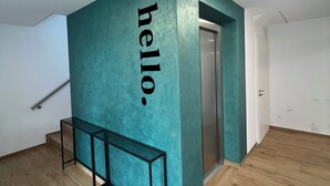 A modern interior with teal accent walls, a wooden floor, and a bench. - Modern cozy purple apartment (Bielefeld)
