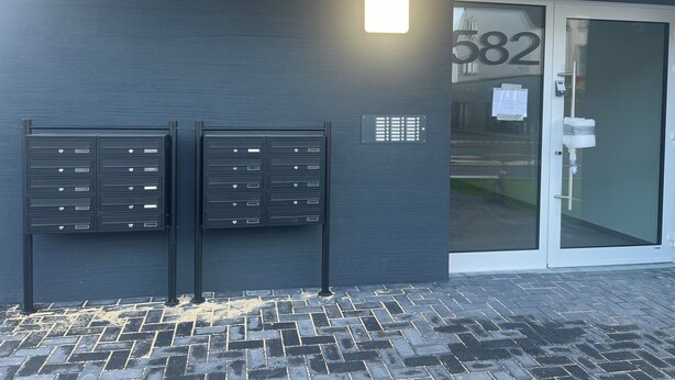 A building entrance with a mailbox and a door marked with the number 682. - Modern cozy purple apartment (Bielefeld)