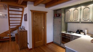 Eine Küche mit Holzboden, einer Holztreppe und einem eingebauten Backofen.