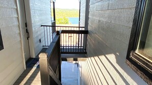 A wooden staircase leading to a balcony with a view of a lake. - Stunning 180° Table Rock Lake View | 2-Min to SDC (Branson)