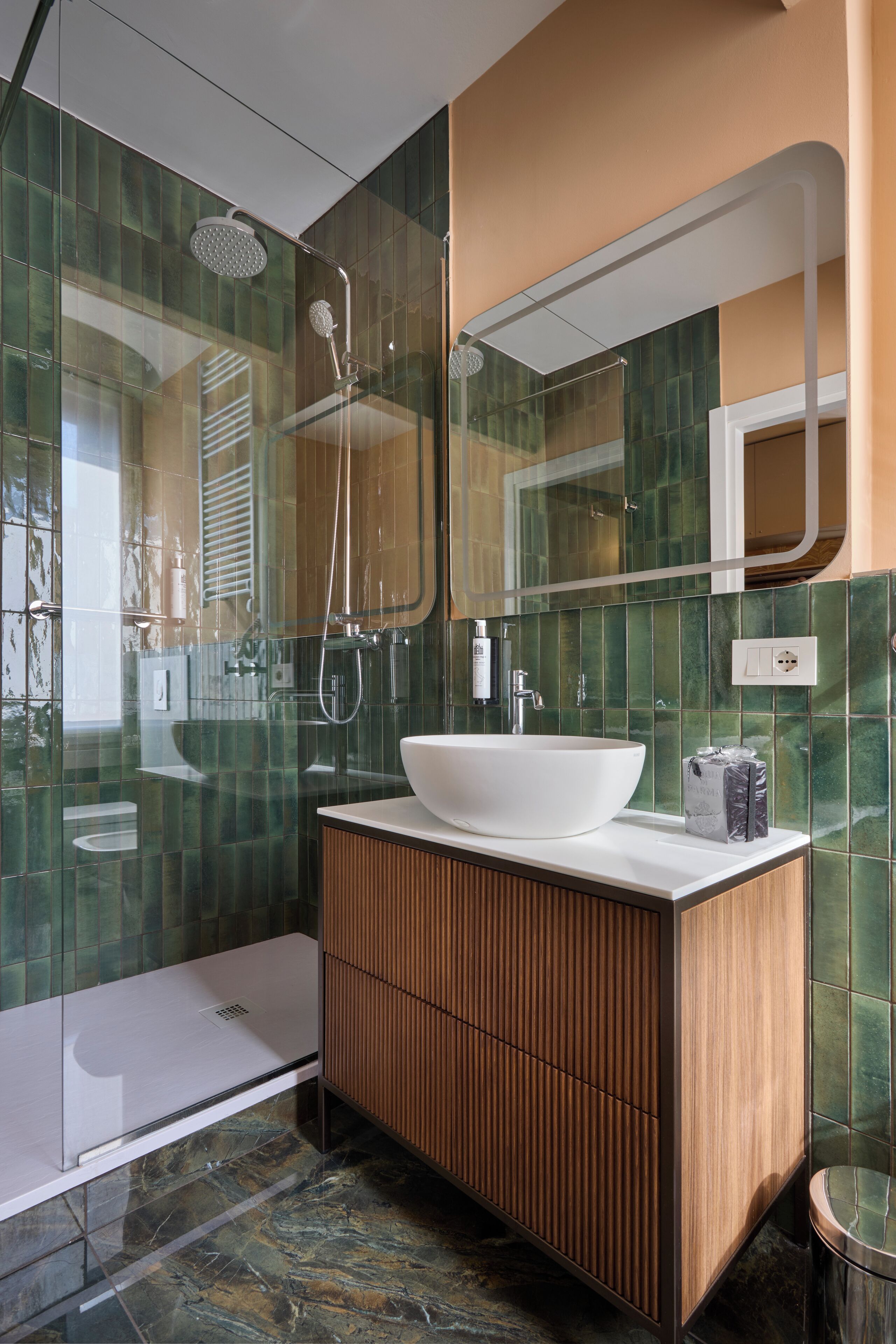 Ein modernes Badezimmer mit einer Duschkabine aus Glas, einem weißen Waschbecken und einem Holzbadezimmer-Möbel.
