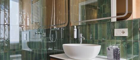 Ein modernes Badezimmer mit einer Duschkabine aus Glas, einem weißen Waschbecken und einem Holzbadezimmer-Möbel.