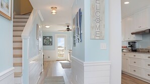 A hallway with a staircase, a ceiling fan, and a welcome sign. - 🌊Dog Friendly-Steps2Bch-Beach Views-Sea Cliff A5 Sunset Shores (Cape San Blas)