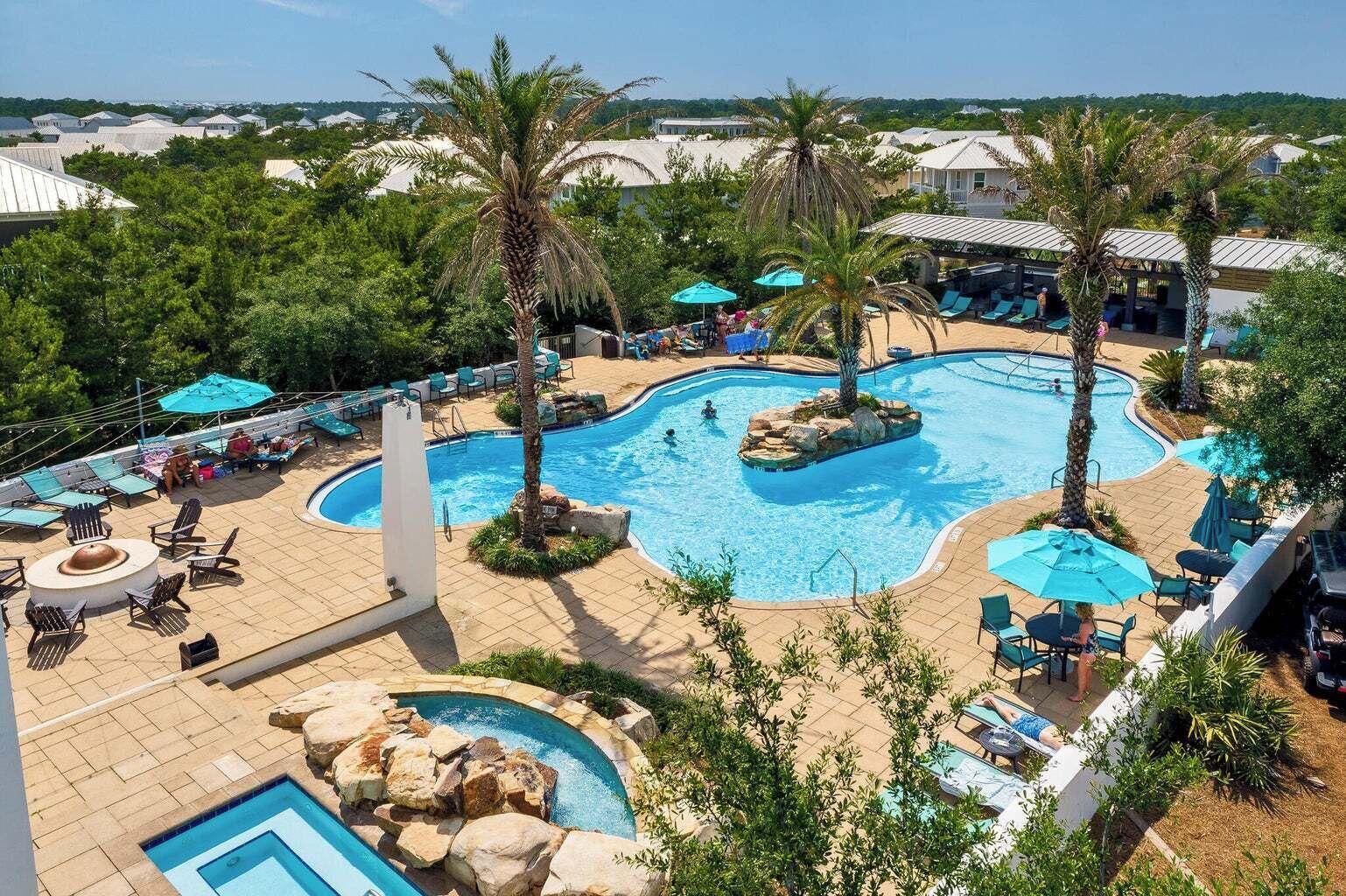 Ein Resort mit einem großen Swimmingpool, Liegestühlen und Palmen.
