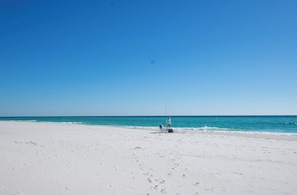 Une plage de sable blanc, sous un ciel bleu azur.